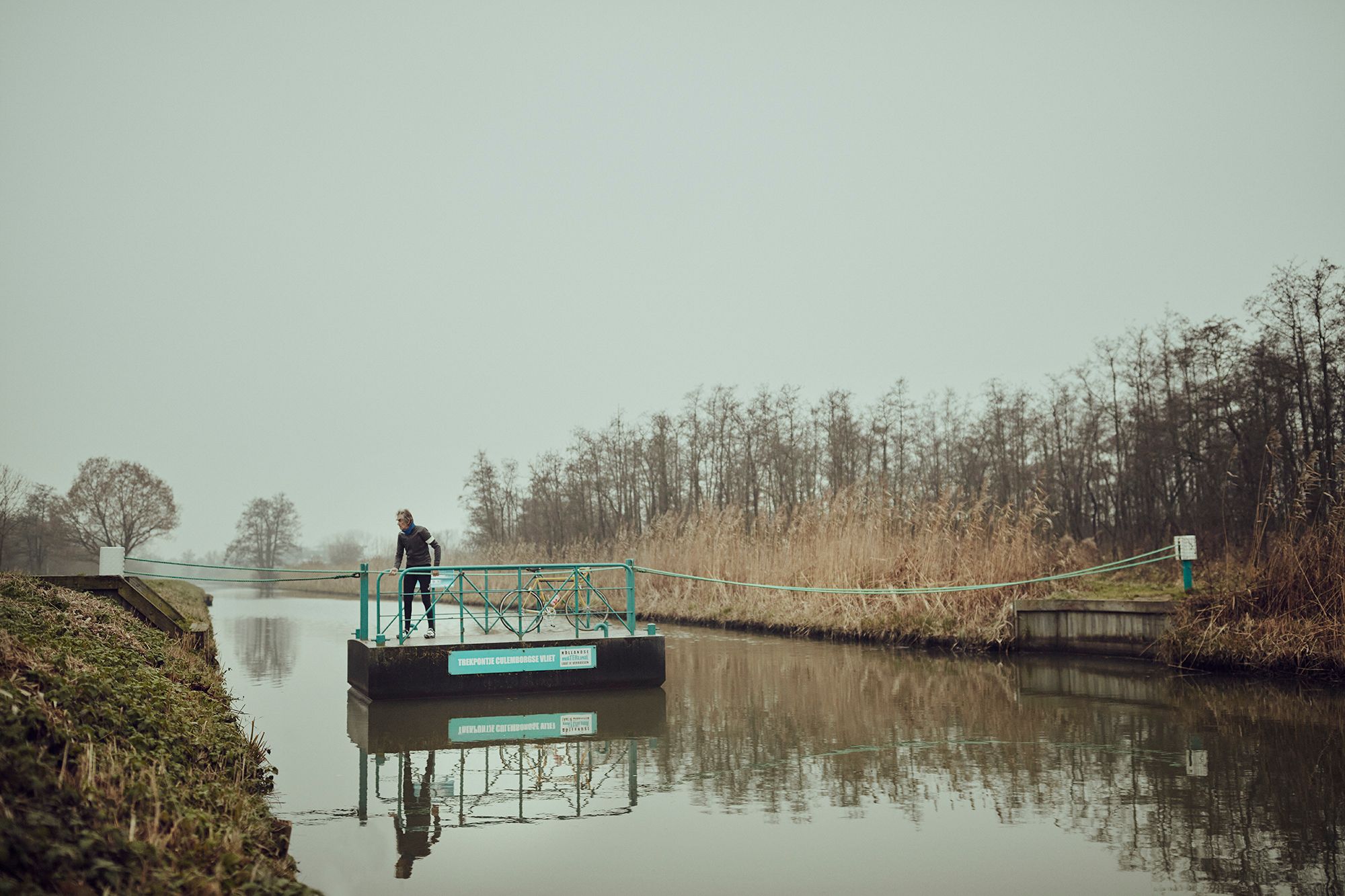 Albert standing with his bicycle on a small ferry