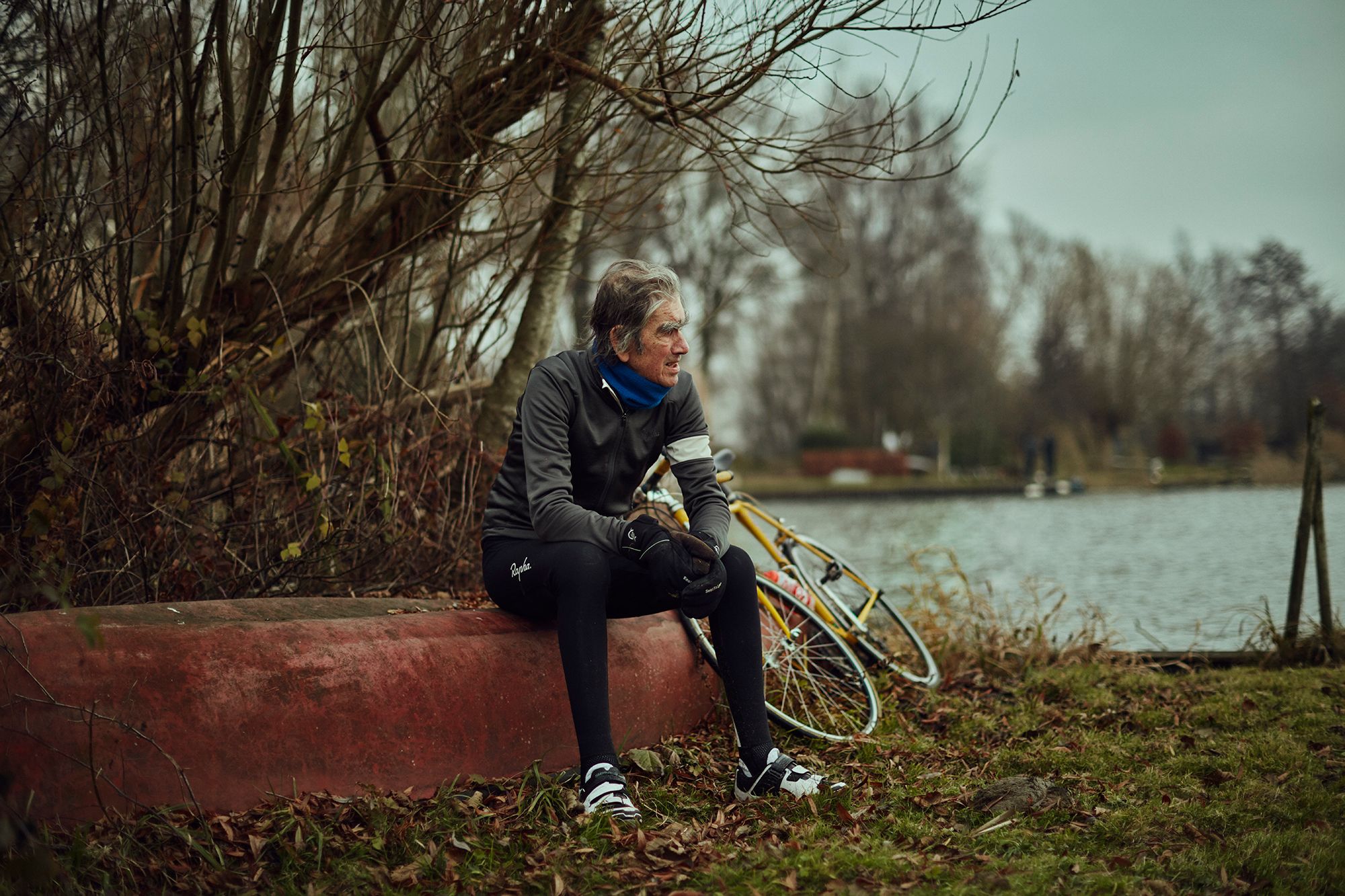 Albert resting beside his yellow bicycle near the water