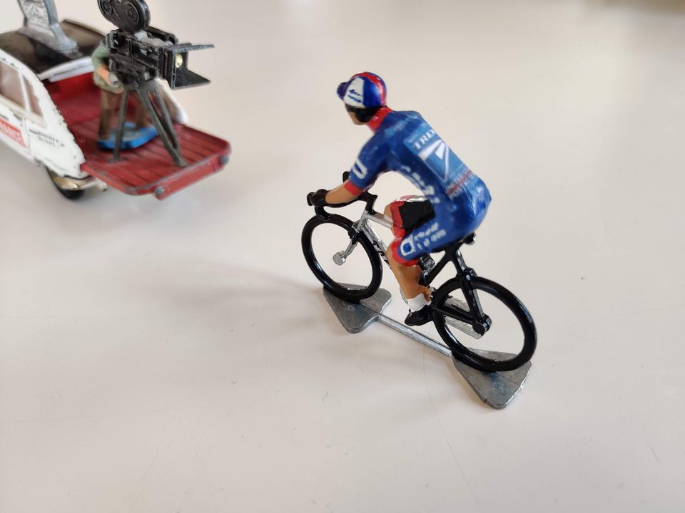 Later miniature cyclist in a blue team jersey