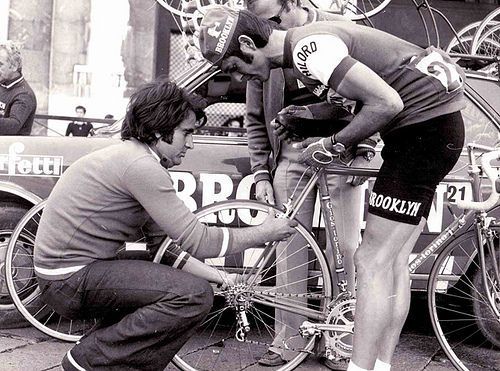 Aldo Gios adjusting a blue GIOS racing bicycle beside Roger De Vlaeminck