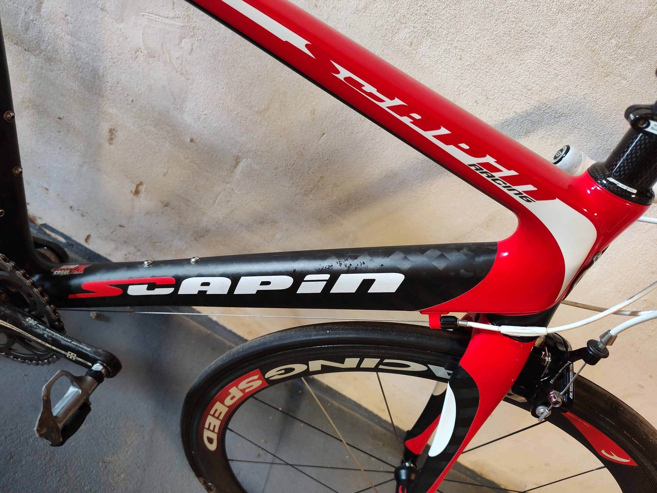 Wide black carbon down tube and red top tube of the Scapin K6