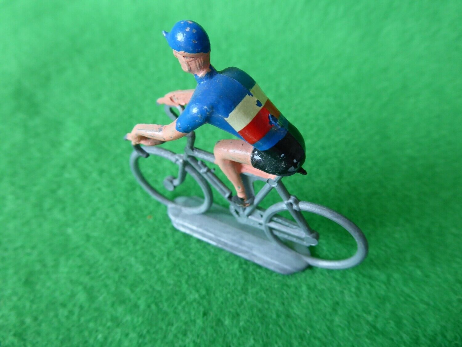 Older hand-painted miniature cyclist in French colours seen from behind