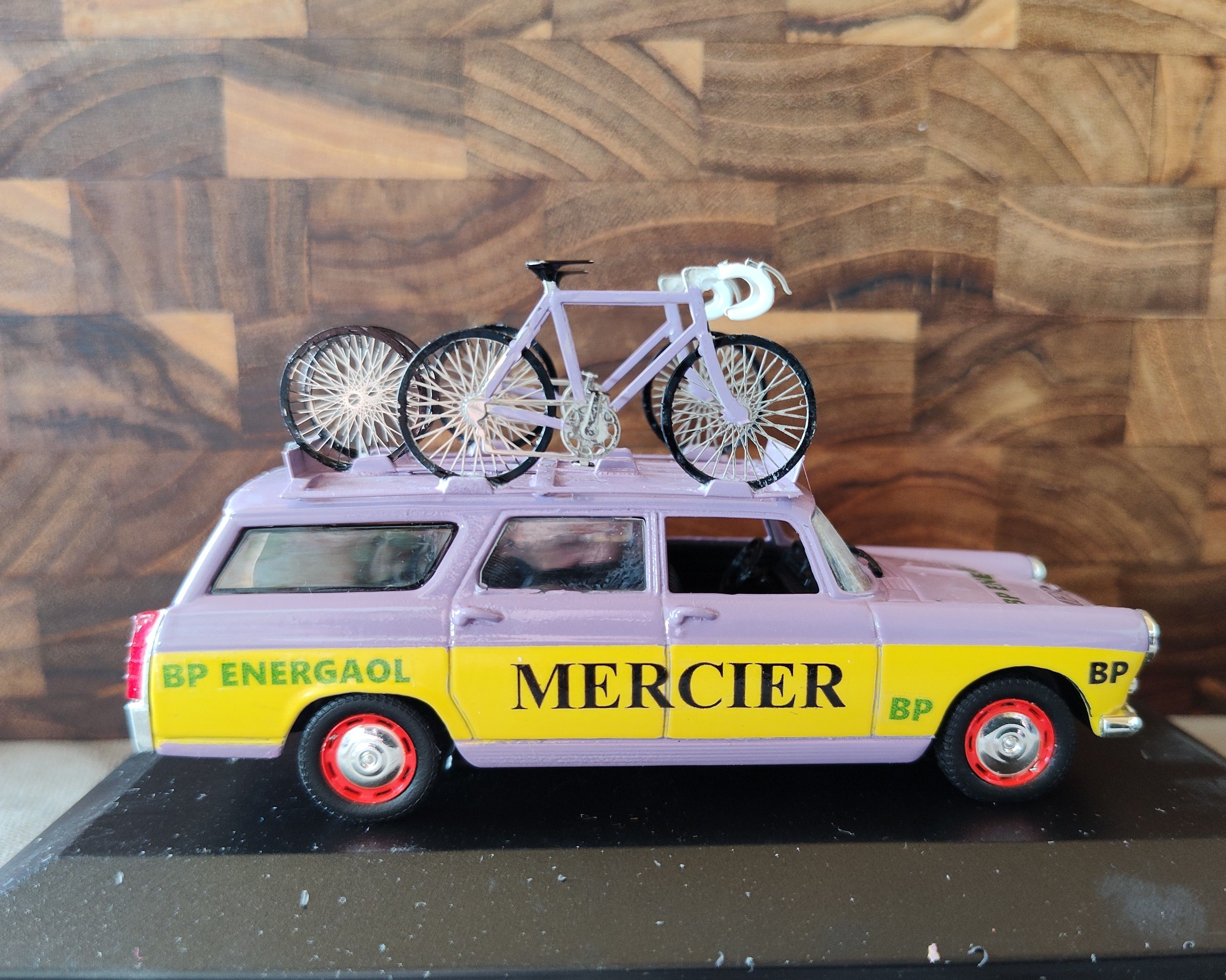 Purple and yellow Mercier miniature service car with bicycles on its roof