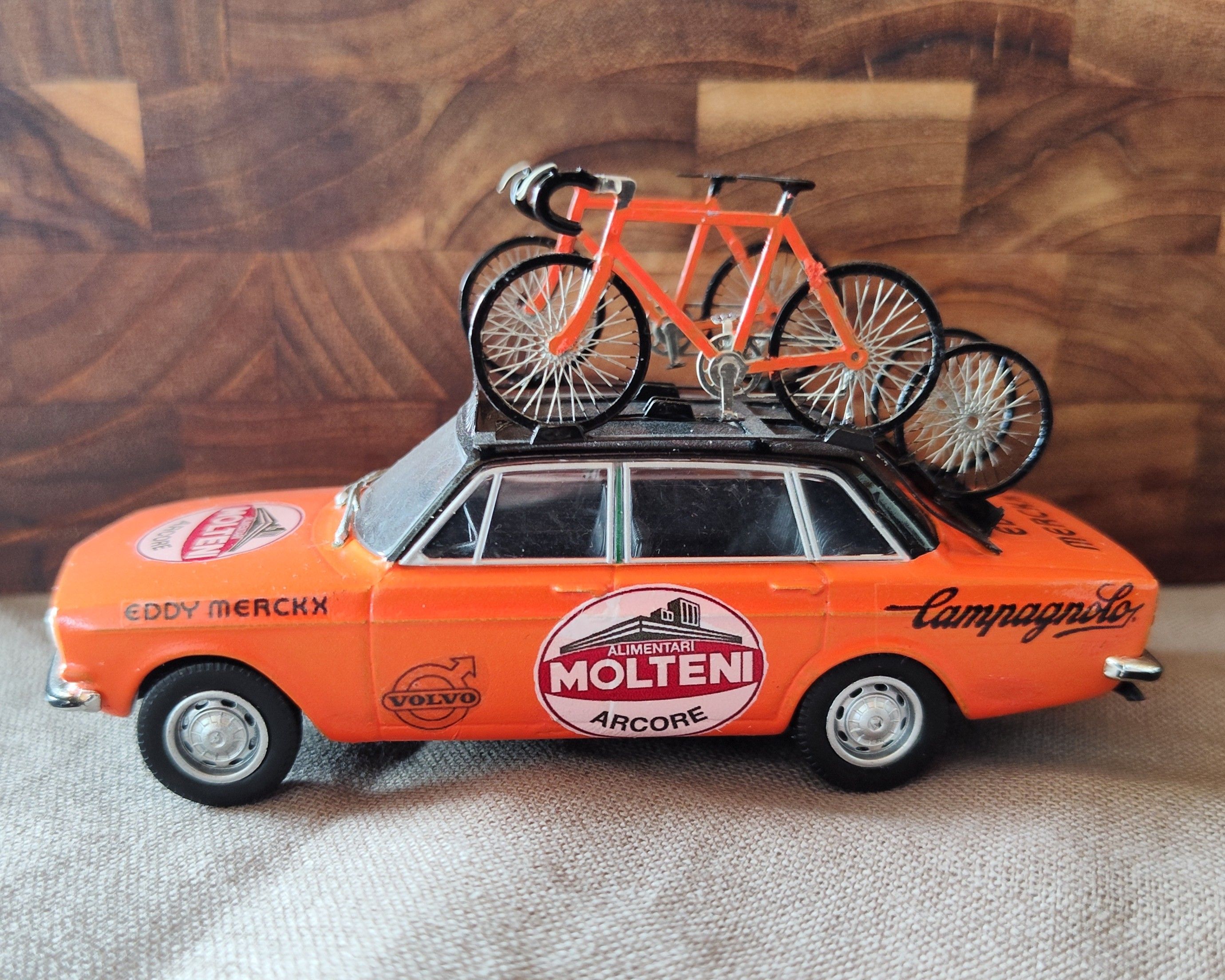 Orange Molteni Volvo miniature service car with bicycles on its roof