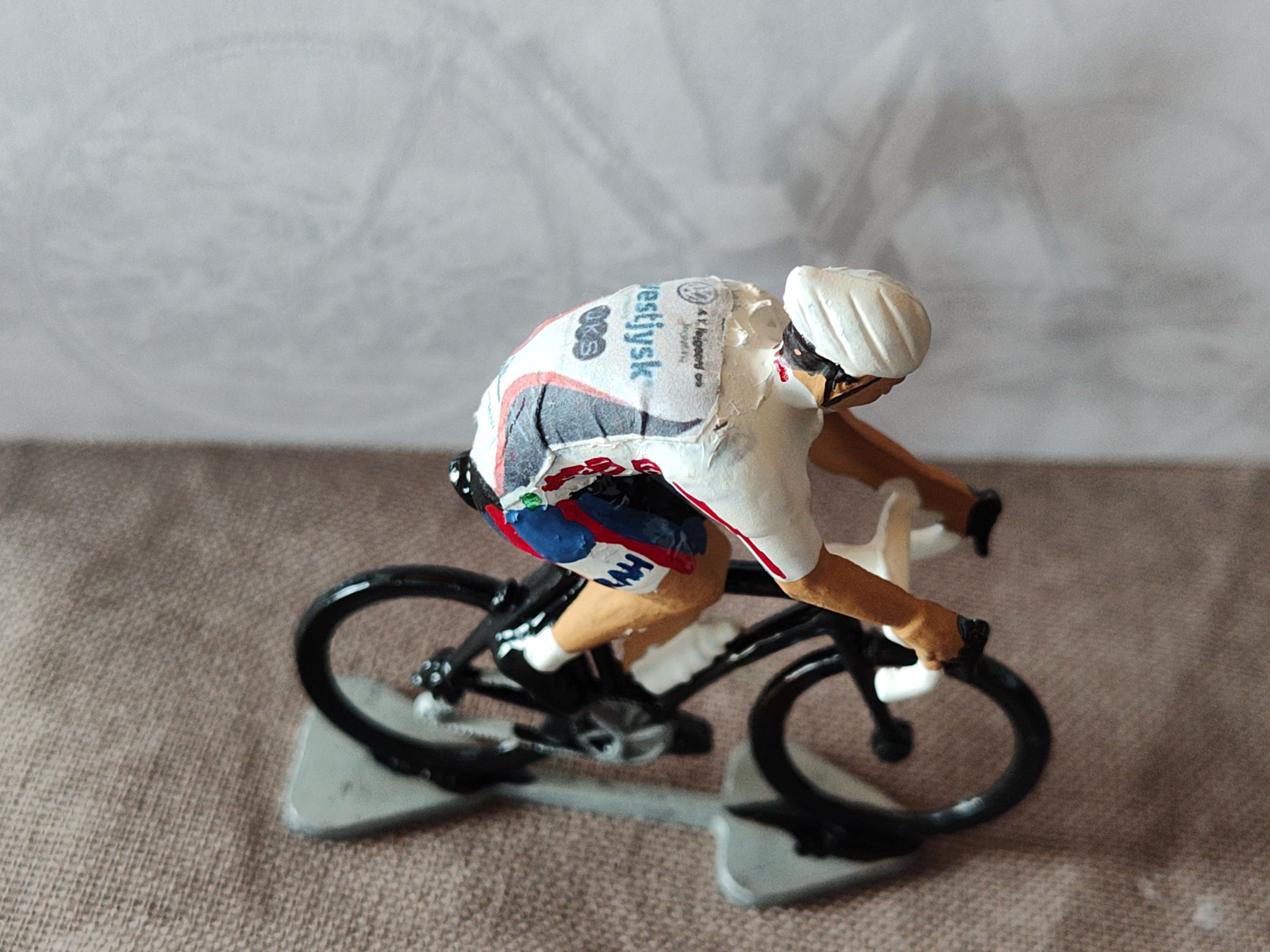 Close view of a miniature cyclist in a white team jersey