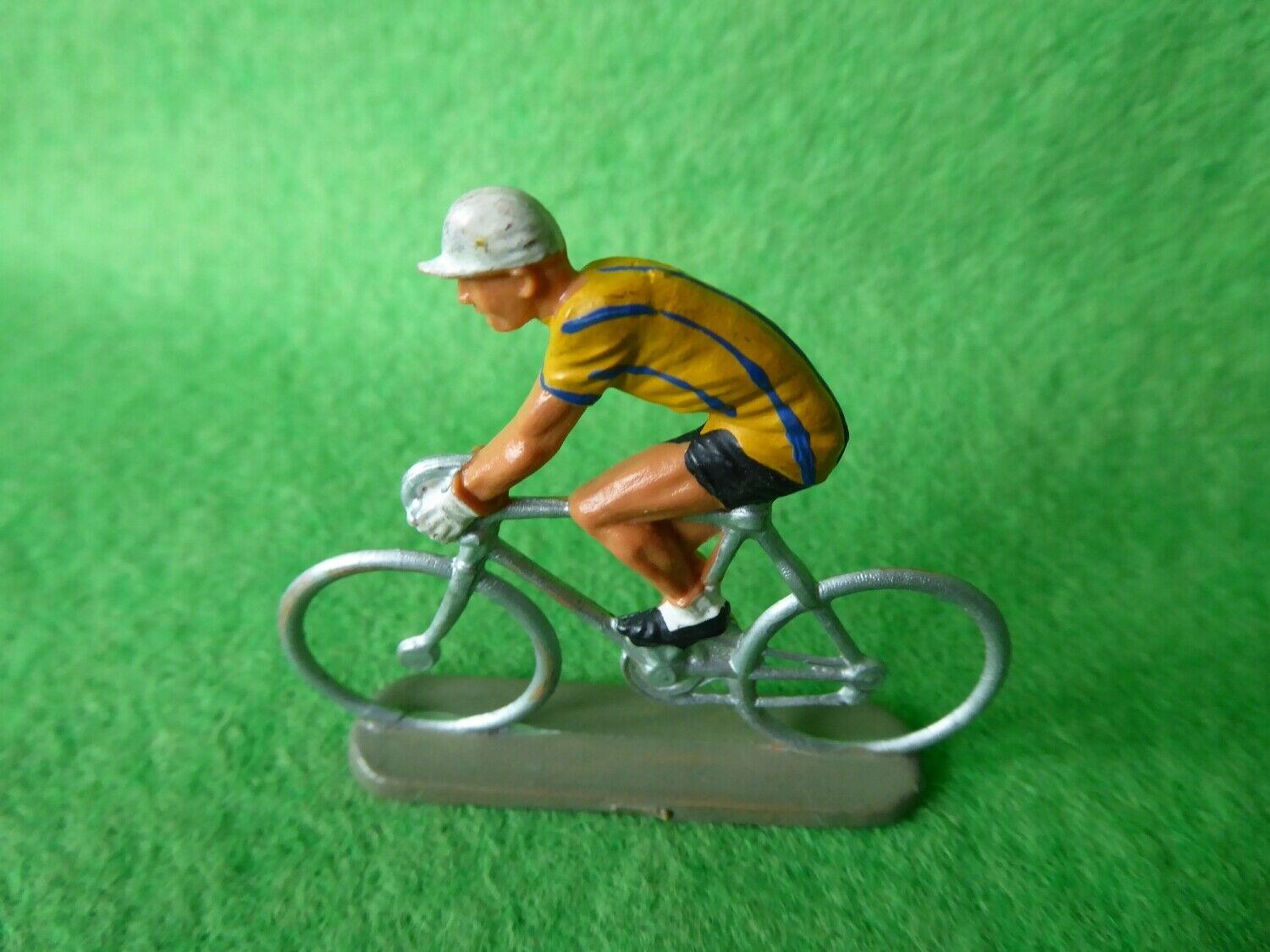 Miniature cyclist in a yellow jersey on a cast base