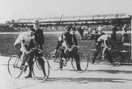 Cyclists sprinting around 1900