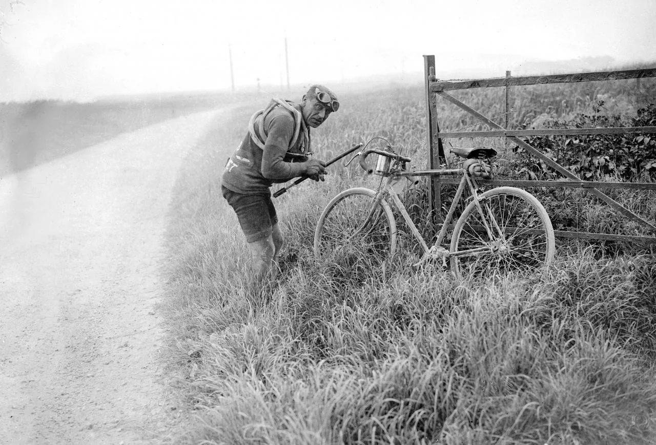 Eugène Christophe repairing his bicycle at the roadside